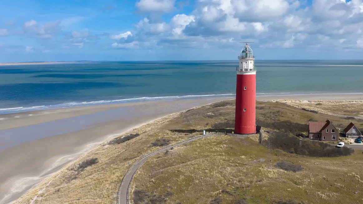De rode vuurtoren van Texel aan de noordpunt van het eiland, met strand en duinen