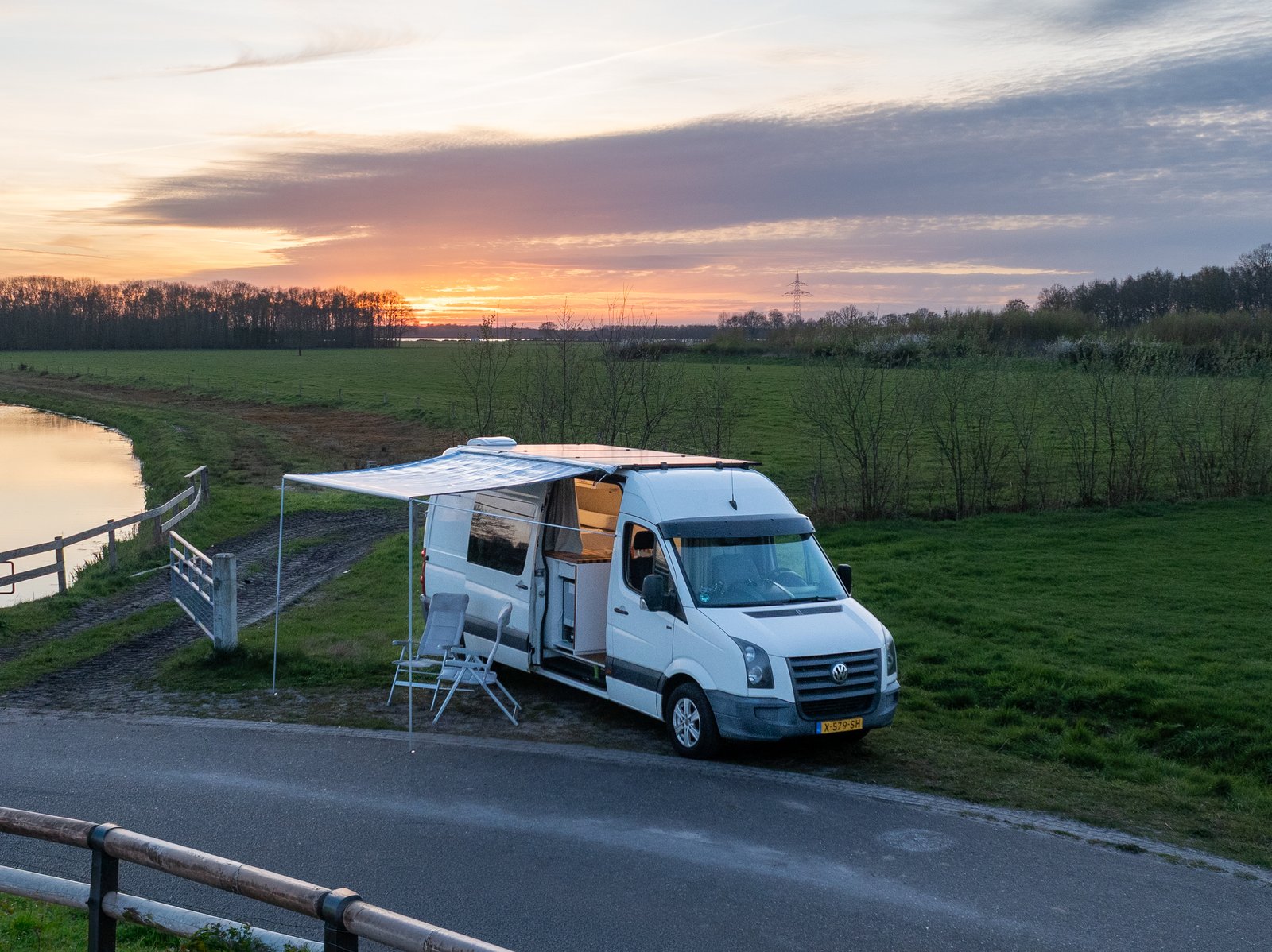 Campervan parked on a quiet Dutch road with fields in the background