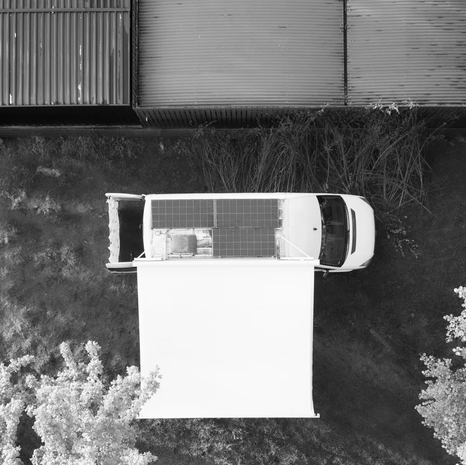 Drone-opname van bovenaf: zonnepanelen op het dak van een Adelaar buscamper